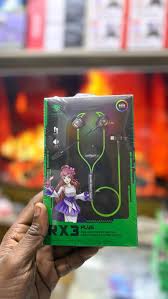 Hand holding a green and black product packaging with a character design.

